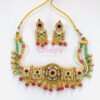 An antique gold-toned choker necklace and earring set featuring intricate designs, pearls, and colorful stones.