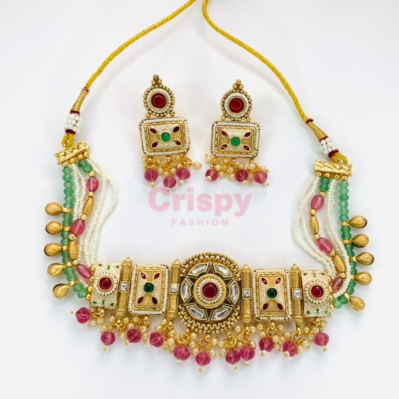 An antique gold-toned choker necklace and earring set featuring intricate designs, pearls, and colorful stones.