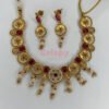 An antique gold-plated necklace and earring set featuring traditional Meena work, likely with red and white stone accents.