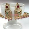 An antique gold-toned choker necklace and earring set featuring intricate designs, pearls, and colorful stones.