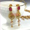 An antique gold-plated necklace and earring set featuring traditional Meena work, likely with red and white stone accents.