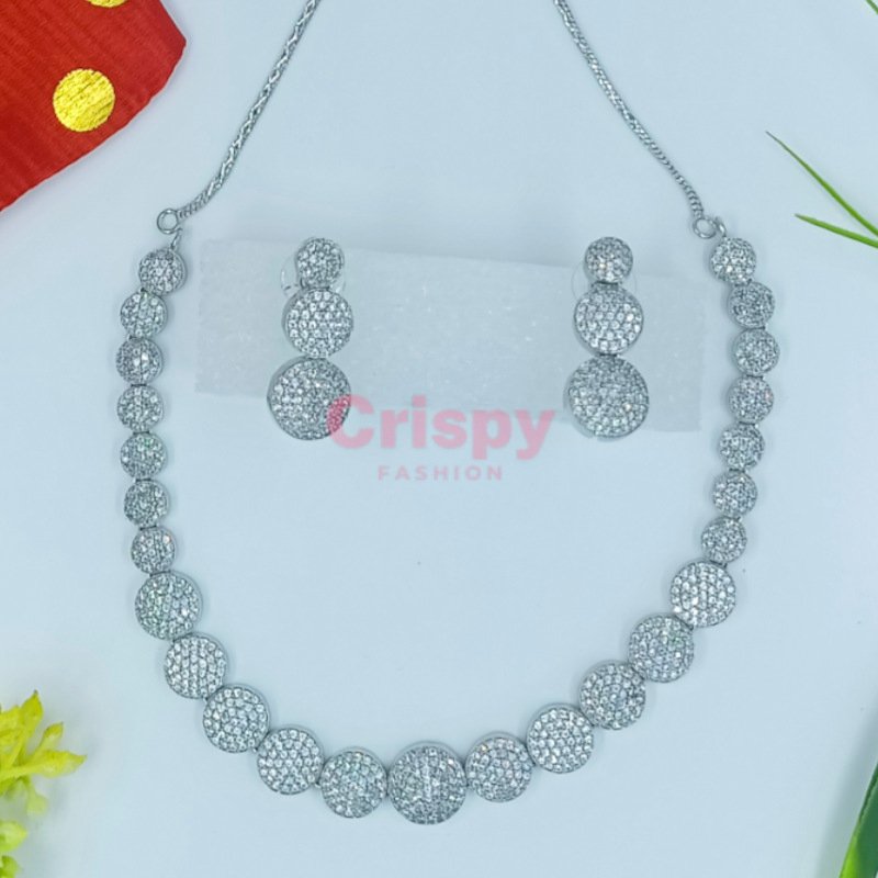 A silver-toned necklace and earring set featuring clear American diamonds.
