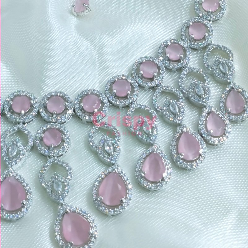 A pink and silver necklace set featuring American diamonds.