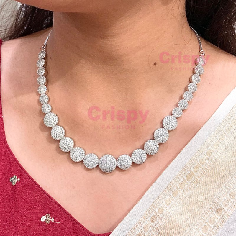 A silver-toned necklace and earring set featuring clear American diamonds.
