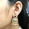 An antique gold-toned choker necklace and earring set featuring intricate designs, pearls, and colorful stones.