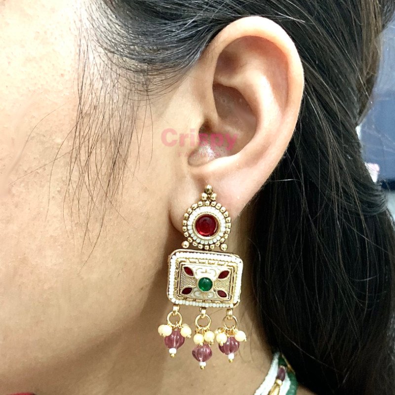 An antique gold-toned choker necklace and earring set featuring intricate designs, pearls, and colorful stones.